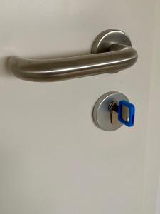 a metal door handle with a blue latch at gemütliches Dachgeschoss in Bonn