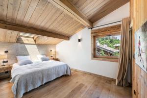 a bedroom with a large bed and a window at Résidence Hermine - Chalets pour 9 Personnes 664 in Megève