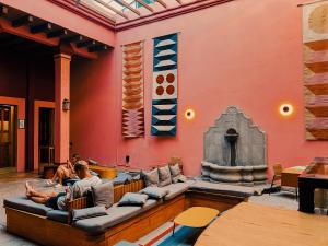 a man sitting on a couch in front of a wall at Viajero Oaxaca Hostel in Oaxaca City