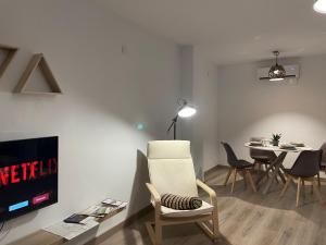 sala de estar con TV y mesa con sillas en Barri Vell 4 en Manresa