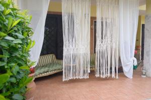 a room with white curtains and a green couch at A Casa di Lu' Elegant Rooms in Monterotondo