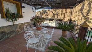 d'une terrasse avec une table et des chaises sur un balcon. dans l'établissement Cueva la Tita del Pan, à Bácor