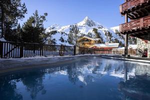 a swimming pool with a snow covered mountain in the background at Résidence Auberge Jerome - 4 Pièces pour 8 Personnes 014 in Arc 1950