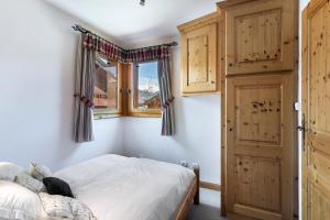 1 dormitorio con cama y ventana en Résidence Dandrina - Chalets pour 8 Personnes 274, en le Praz