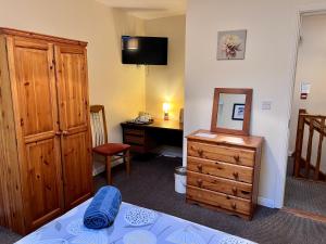 een slaapkamer met een bed, een dressoir en een bureau bij Prestashortstays in Belfast