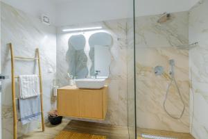 bagno con lavandino e doccia di Sarita's Apartments & Suite a Laganas