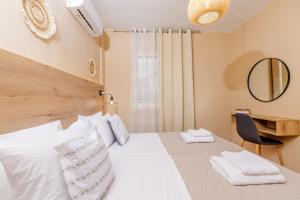 a bedroom with a bed and a desk and a mirror at Sarita's Apartments & Suite in Laganas
