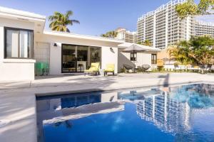 a house with a swimming pool next to a building at Modern Beach Home, Family Friendly, Heated Pool in West Palm Beach