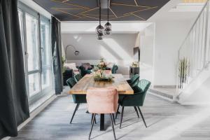 a dining room with a wooden table and green chairs at Luxury 4 Bedroom Apartment/Therme Erding/Parking in Erding +18 photos
