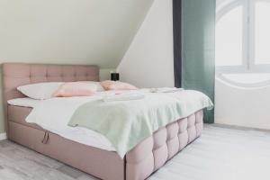 Cama rosa con sábanas blancas y almohadas rosas en Luxury 4 Bedroom Apartment/Therme Erding/Parking en Erding