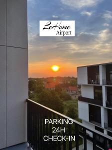 einen Blick auf den Sonnenuntergang vom Balkon eines Apartments in der Unterkunft LeHome Airport Wroclaw in Breslau