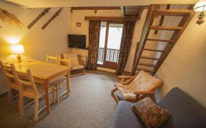 a living room with a table and chairs and a ladder at Résidence Le Pouzenc - Studio pour 6 Personnes 424 in Les Orres