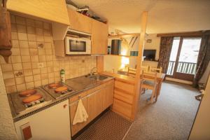 a kitchen with a sink and a stove top oven at Résidence Le Pouzenc - Studio pour 6 Personnes 424 in Les Orres