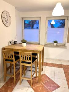 a dining room with a wooden table and two windows at Casa Bella in Guxhagen