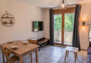 a living room with a wooden table and a television at Résidence L'horizon - Studio pour 4 Personnes 584 in Les Orres