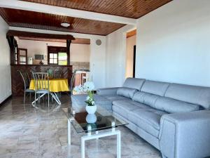 a living room with a couch and a table at VILLA DES PALMIERS in Le Marin