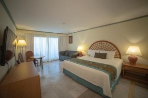 a hotel room with a large bed and a couch at Samba Vallarta All Inclusive in Nuevo Vallarta