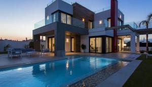 een groot huis met een zwembad ervoor bij LA Paradise in Los Alcázares