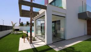 una casa blanca con puertas de cristal y un patio en LA Paradise, en Los Alcázares