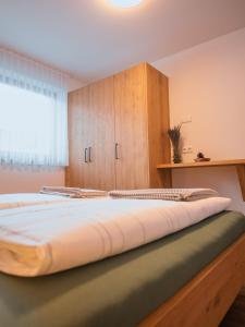 a large bed in a room with a window at Zum Sonnentor App Larix in Lutago