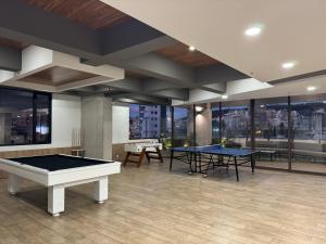 two ping pong tables in a room with windows at Edificio SENSE in Quito
