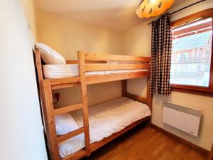2 stapelbedden in een kleine kamer met een raam bij Les Chalets Des Rennes - 3 Pièces pour 6 Personnes 754 in Vars