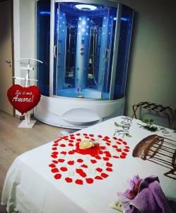 a room with a shower with red roses on a bed at La Casa Dei Sogni in Gallico