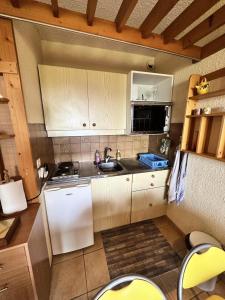 a small kitchen with white cabinets and a sink at Résidence Les Glovettes - Studio pour 4 Personnes 954 in Villard-de-Lans