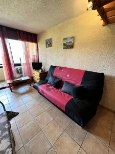 a black and red couch in a living room at Résidence Les Glovettes - Studio pour 4 Personnes 954 in Villard-de-Lans