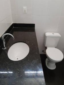 La salle de bains est pourvue de toilettes blanches et d'un lavabo. dans l'établissement Casa 4 quartos paraiso santa efigênia reg residenc, à Belo Horizonte