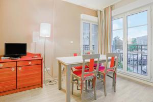 a dining room with a table and chairs and a window at Résidence Port Guillaume - maeva Home - 2 Pièces 4 Personnes Sélection MAE-6688 in Dives-sur-Mer