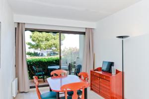 a dining room with a table and chairs and a window at Résidence Les Balcons de Collioure - maeva Home - Studio 4 Personnes Confort MAE-5972 in Collioure