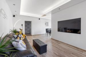 sala de estar con sofá y TV en la pared en LOFT 73 en Cannobio