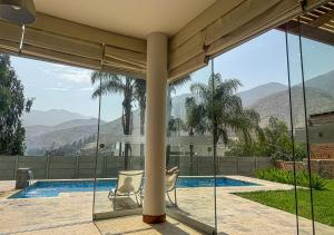 a house with a view of a swimming pool and mountains at KUSI WASI CIENEGUILLA in Cieneguilla