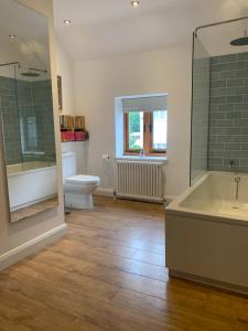 a bathroom with a tub and a toilet and a sink at Stable Cottage in Tettenhall +19 photos