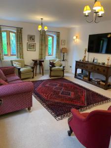 a living room with red furniture and a flat screen tv at Stable Cottage in Tettenhall