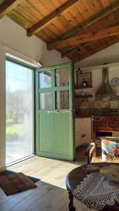 a green door in a room with a table at Rizaki Cottage in Nafpaktos in Nafpaktos