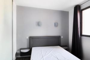 een slaapkamer met een bed en een raam bij Résidence Saint-Raphaël Valescure - maeva Home - Appartement 3 pièces 6 pe 80 in Valescure