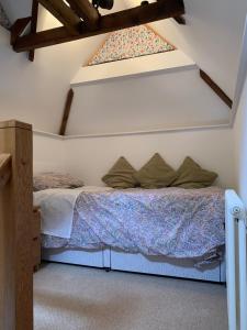 Bett in einem Zimmer mit Fenster in der Unterkunft Stable Cottage in Tettenhall