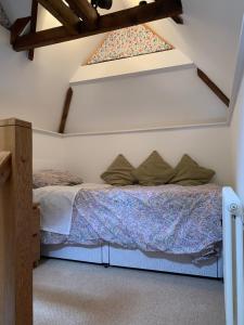 a bed in a room with a window at Stable Cottage in Tettenhall