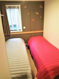 ein Schlafzimmer mit einem Bett und ein Fenster mit Schmetterlingen an der Wand in der Unterkunft Mobil-home 4 pers. proche plage 69085 in Saint-Jean-de-Monts