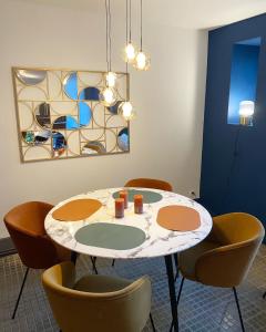 una mesa y sillas en una habitación con una pintura en Casa Miasto, en Aspet