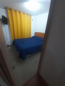 Habitación pequeña con cama con cortina amarilla en Departamento vallenar, en Vallenar