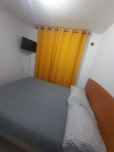 a bedroom with a bed and a yellow curtain at Departamento vallenar in Vallenar