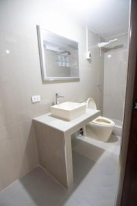 a white bathroom with a sink and a toilet at Estancia Entre Las Nubes in Chachapoyas