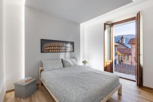 1 dormitorio con cama y ventana grande en LOFT 73 en Cannobio