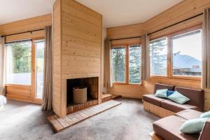 sala de estar con chimenea y ventanas en Chalet Arketa 14 pers. au pied des pistes - Maeva Particuliers - 8 Pièces 14 Personnes Prestige 139510 en Avoriaz