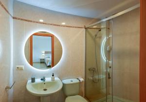 a bathroom with a toilet and a sink and a shower at Apartamentos Costas de Bueu in Bueu