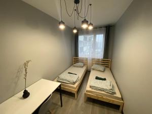 two beds in a room with a window at WORKATION Centre Airport Boutique Designer Bath, 3-4 days best offer, Kitchen, Balkony, Aircon in Warsaw