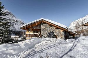 a log cabin in the snow with a pile of snow at Chalet Klosters - Chalets pour 9 Personnes 984 in Val-d'Isère